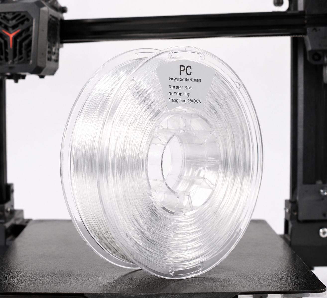 Hướng dẫn in 3D bằng sợi nhựa trên máy tính cá nhân: Cài đặt, yêu cầu kỹ thuật và các loại vật liệu tốt nhất cho năm 2026 Polycarbonate PC filament spool on industrial 3D printer showing transparent material properties