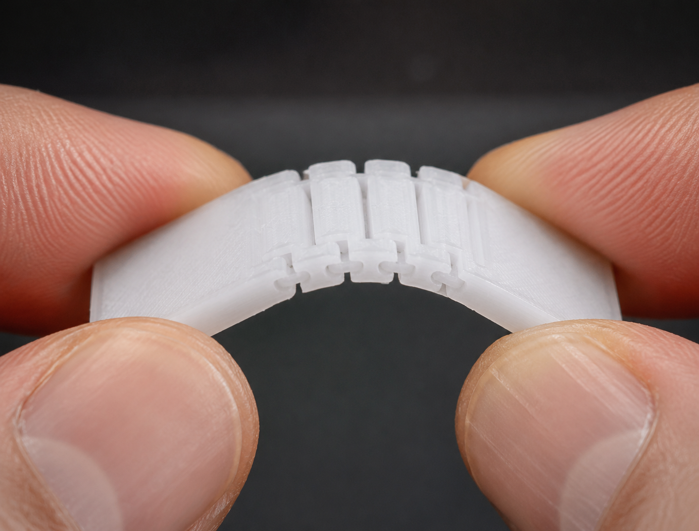 PPフィラメントの3Dプリントガイド:設定、ベッドへの密着、リビングヒンジの設計 Closeup macro photo of PP 3D printed living hinge being flexed, demonstrating flexibility and durability