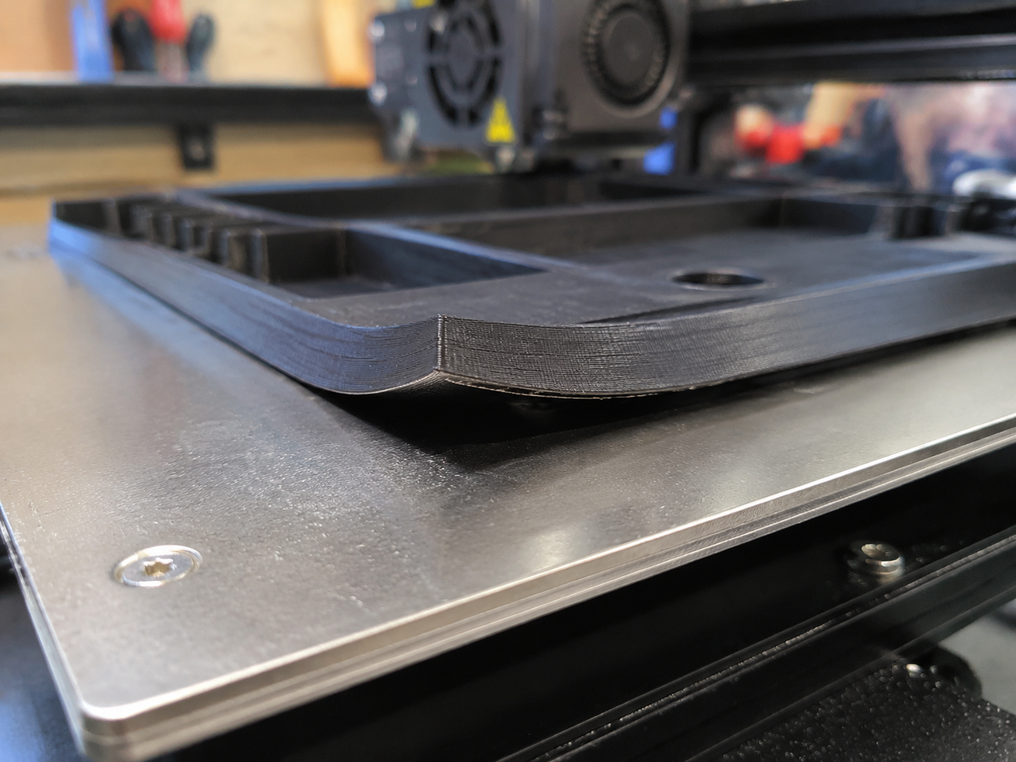 FDM 3D printed part with corner lifting and warping deformation on heated build plate